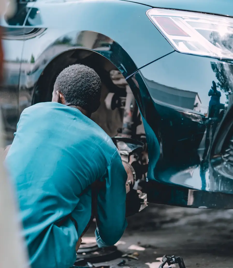 Technician working under a vehicle in a service bay