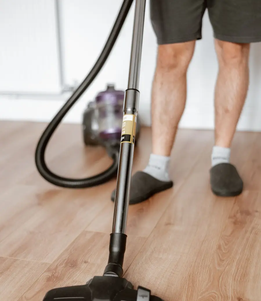 Close view of a vacuum cleaning head being run across flooring