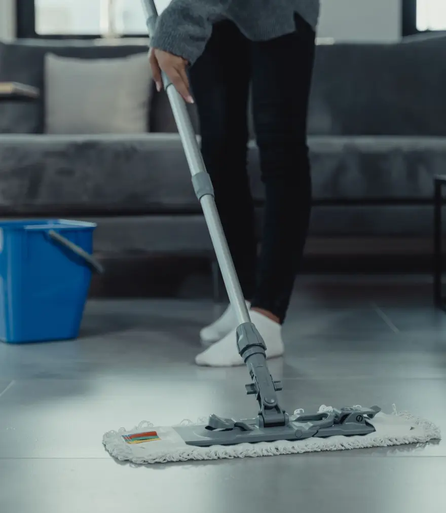 Person mopping a tile floor in a contemporary living room