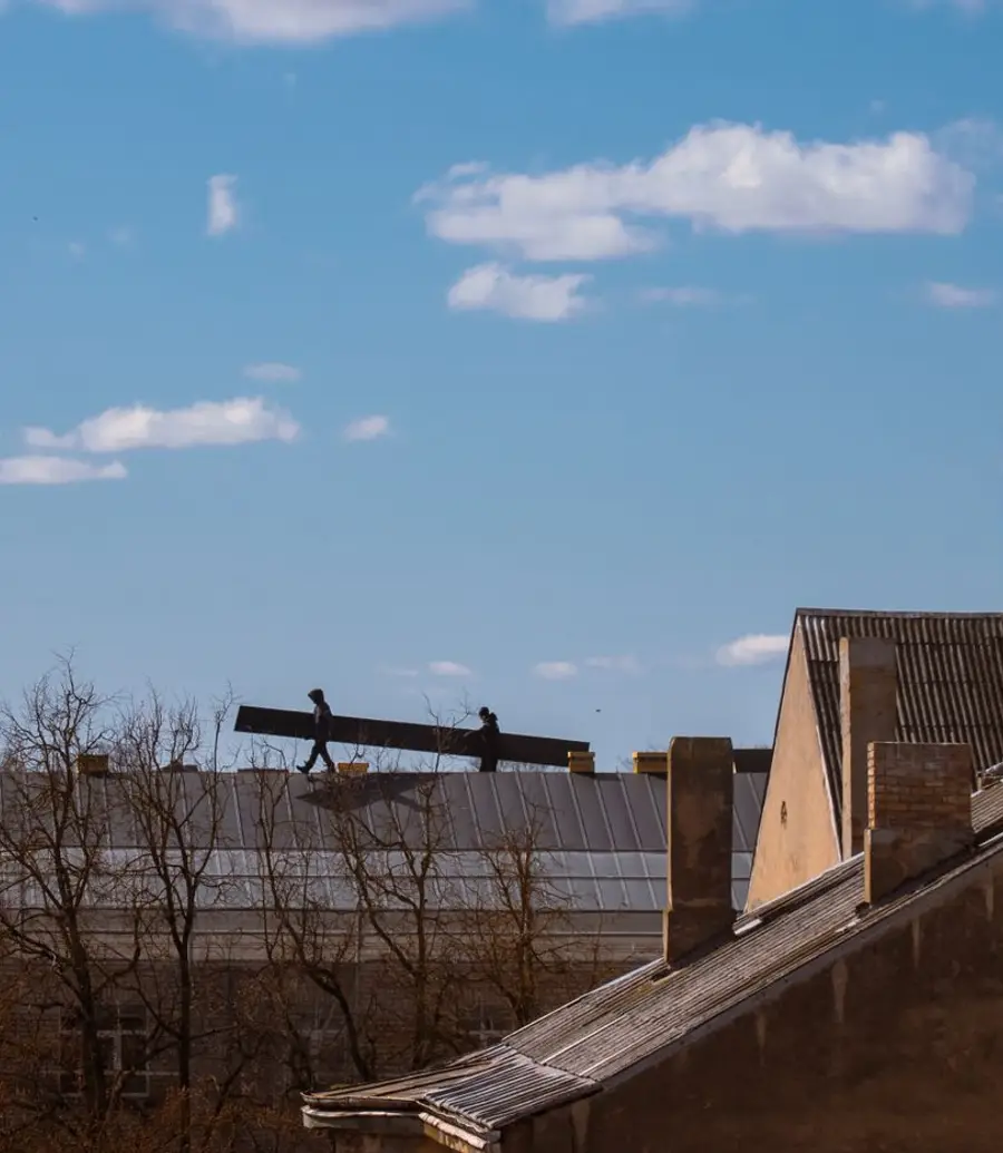 Workers silhouetted on a rooftop in low evening light