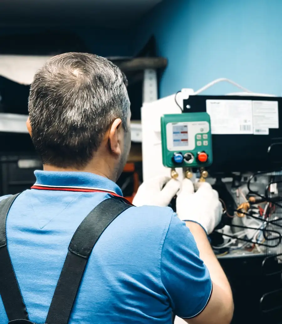 HVAC technician servicing an air conditioning system indoors