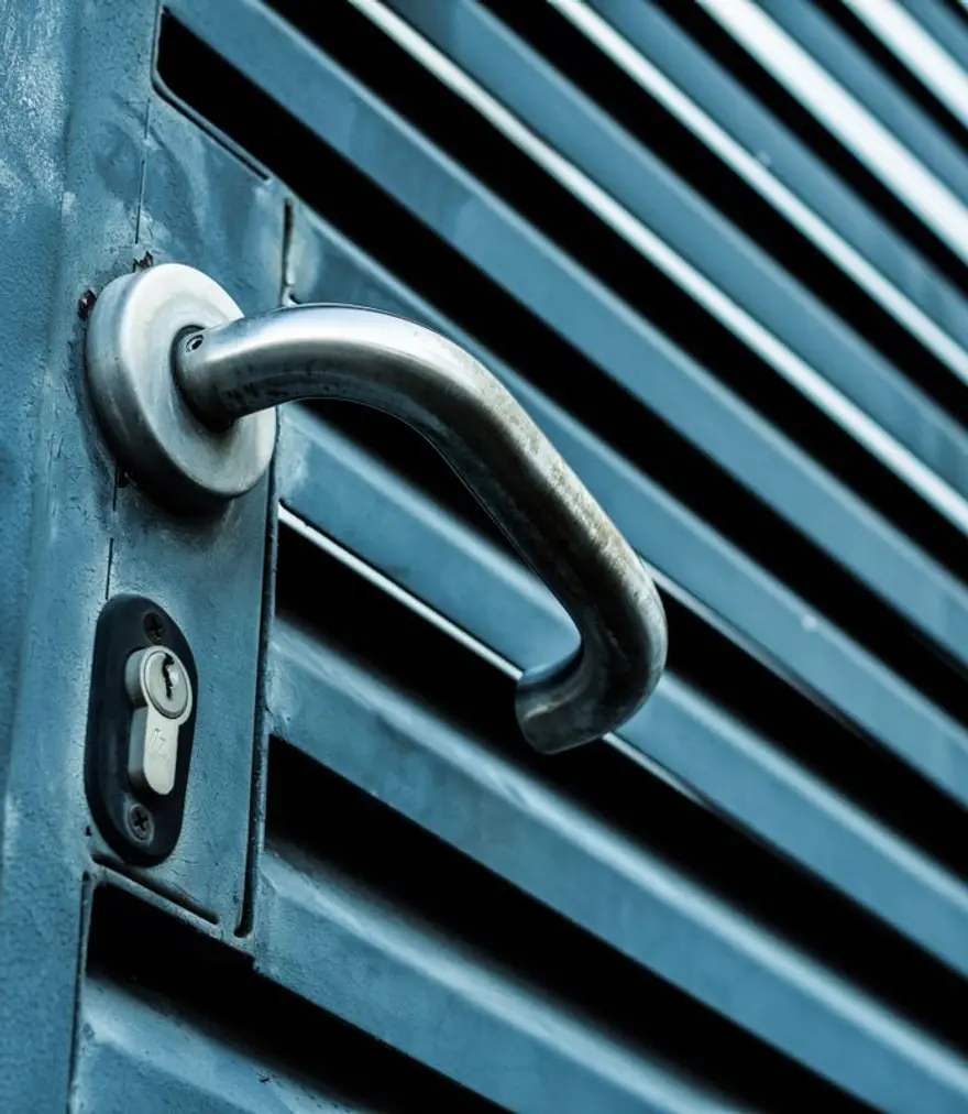 Stainless steel handle and lock cylinder on a metal louvered gate