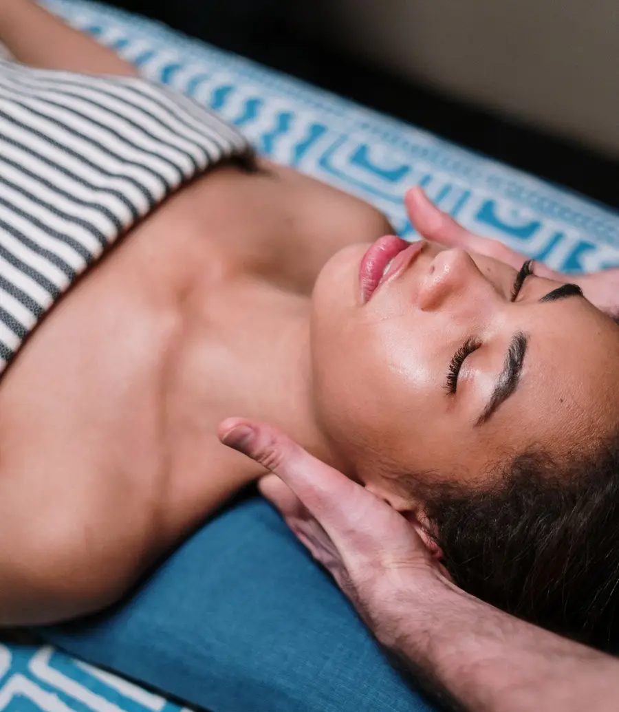A massage therapist's hands working a client's neck and shoulders