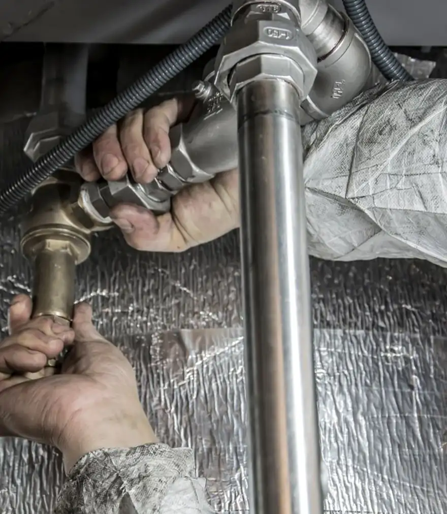Close-up of hands installing steel supply pipes