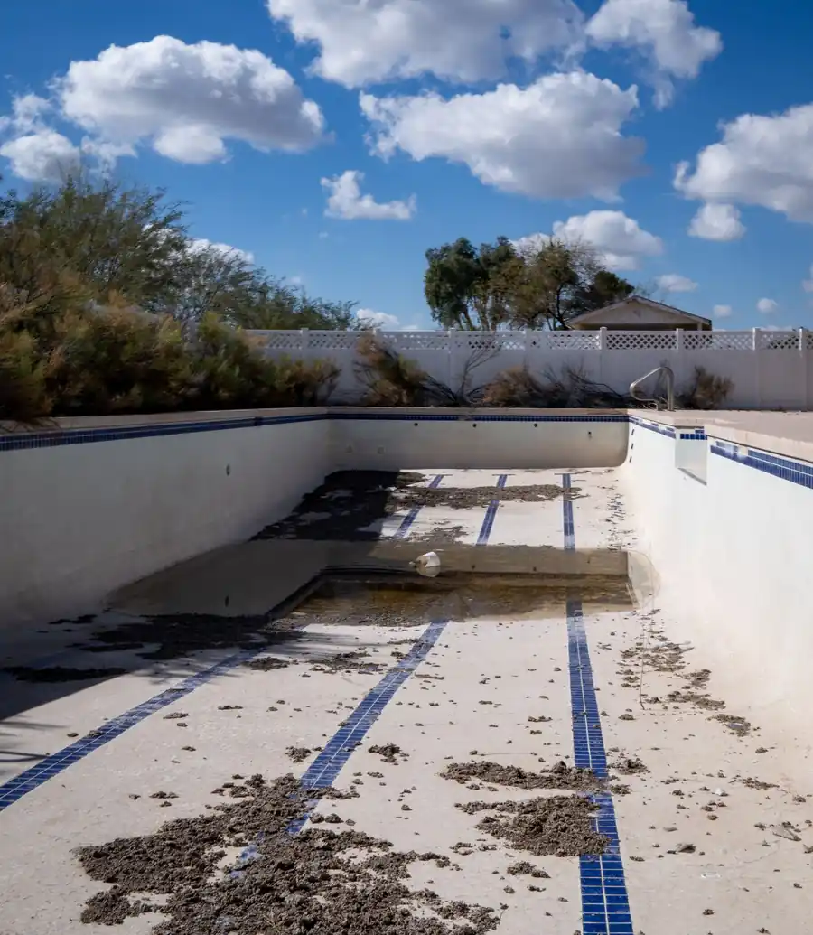 Empty, out-of-service swimming pool needing major work