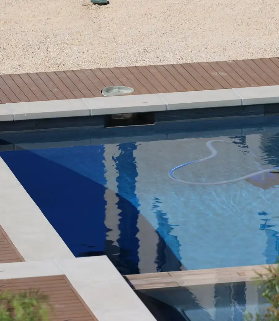 Pool cleaning vacuum hose and head resting in a swimming pool