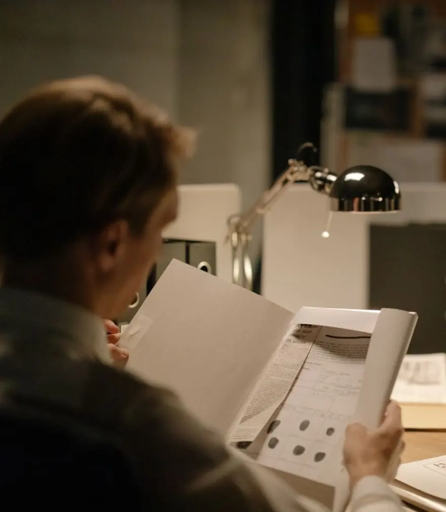 Investigator reviewing a confidential case file at an office desk