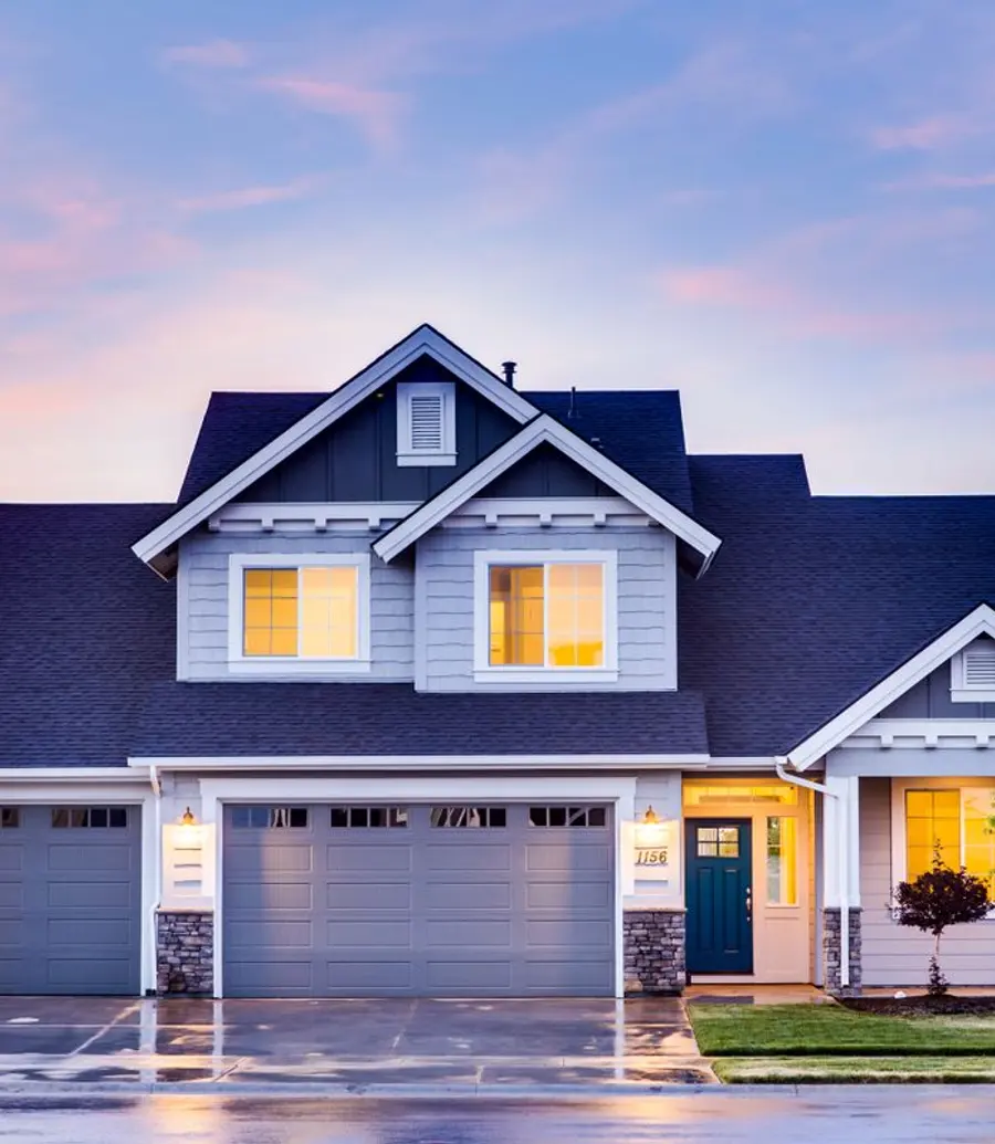 Suburban home at twilight with the windows lit