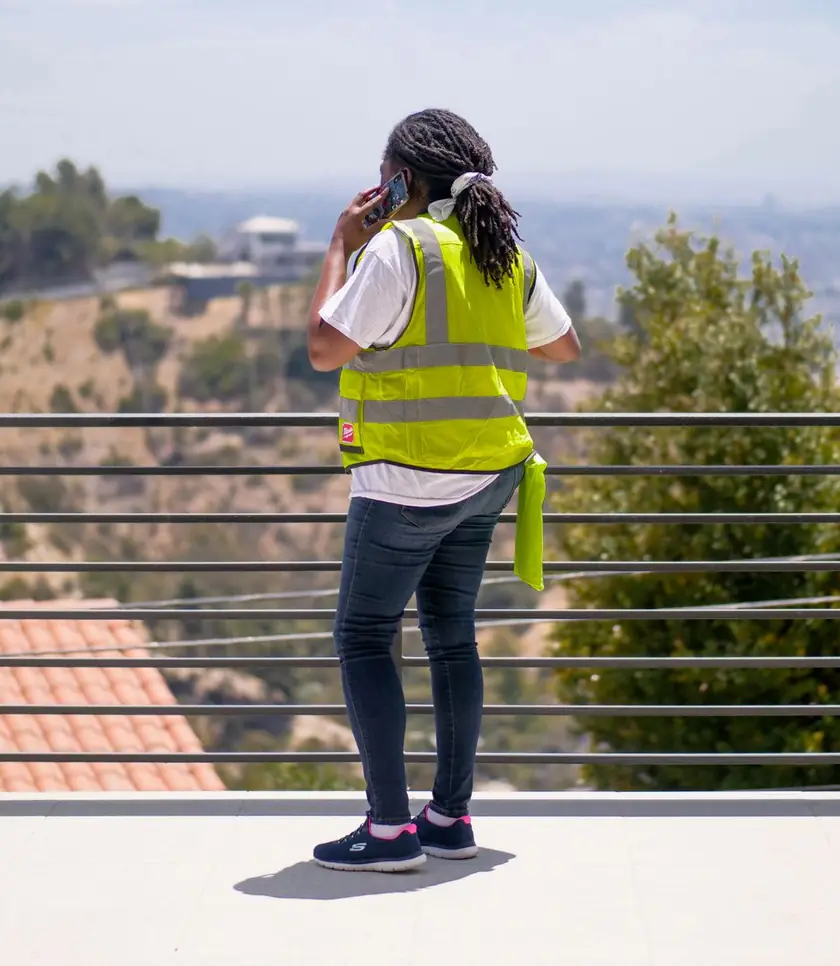 Worker in a hi-vis vest taking a call on site