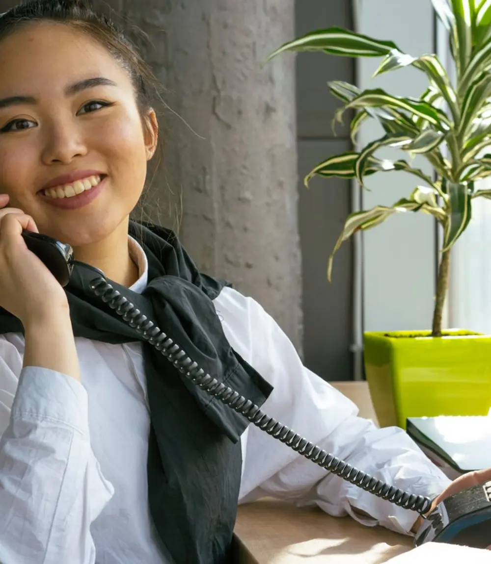 Accountant smiling while booking a client over the phone