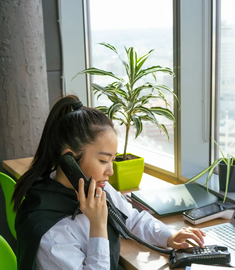 Accountant on the phone while working at a laptop during a busy day