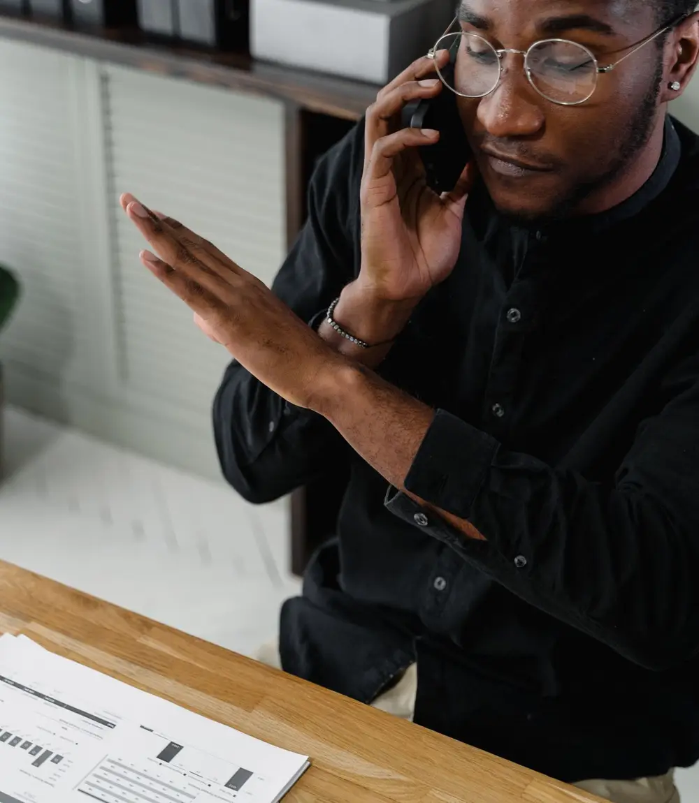 Accountant taking a call and reviewing reports at a desk