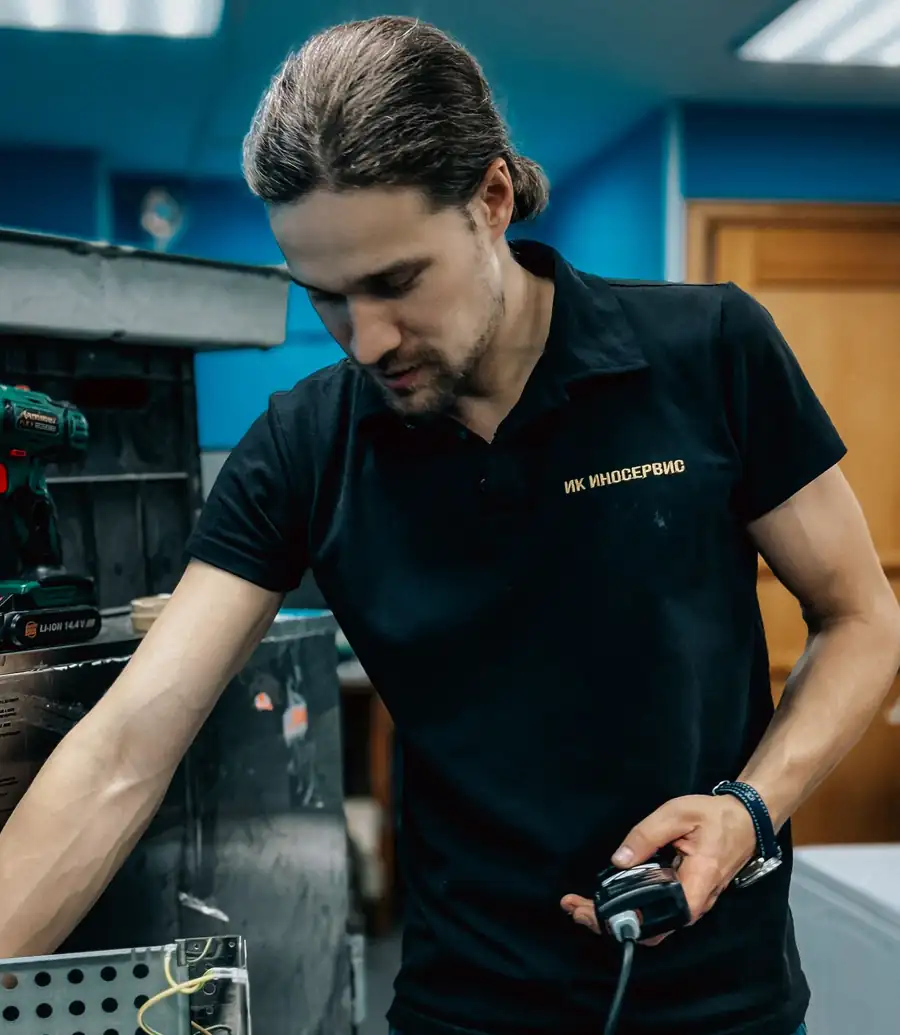 Appliance technician using a tool on an open appliance panel