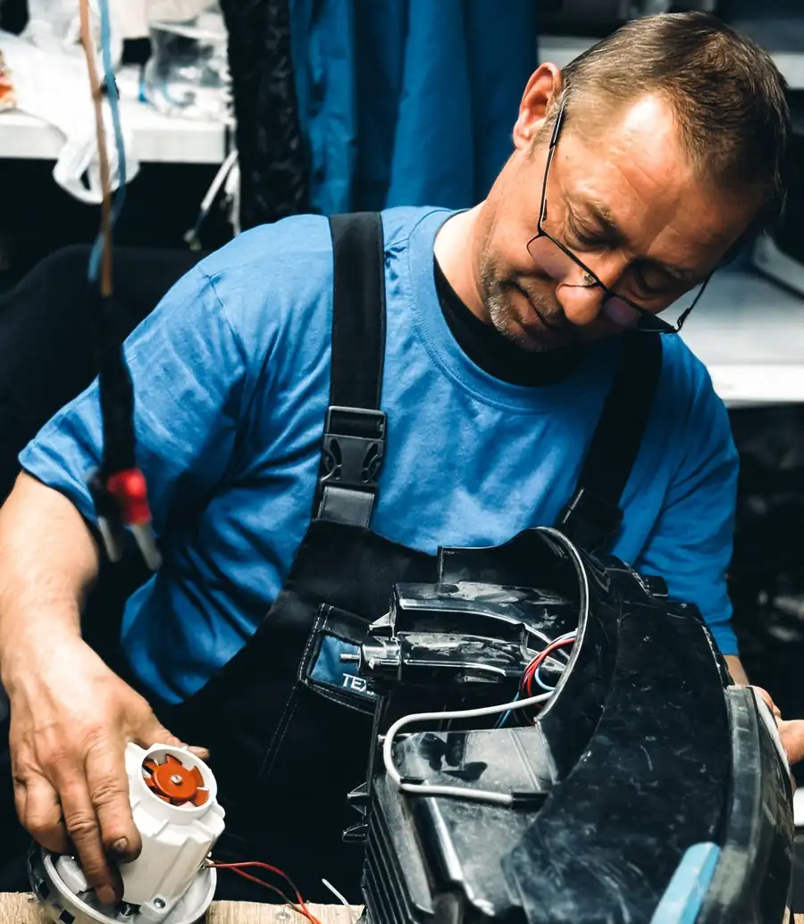 Technician repairing an appliance motor on a workbench