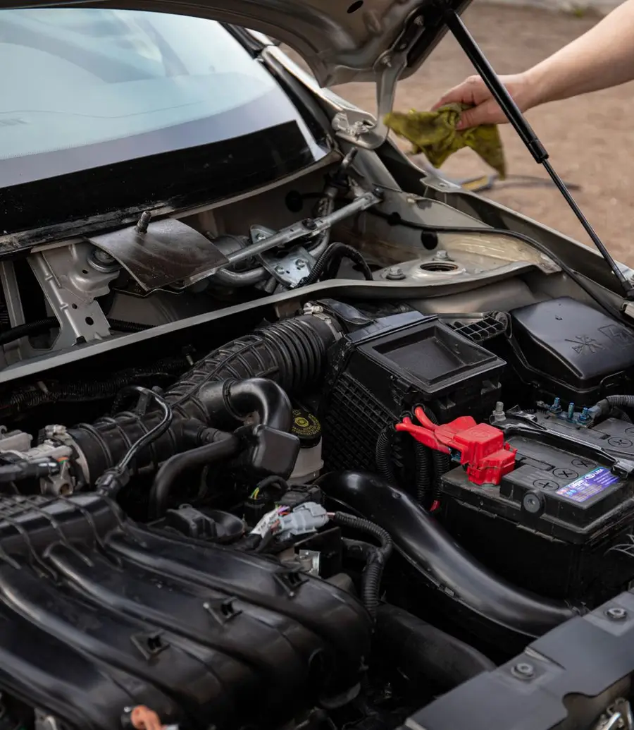 Mechanic inspecting a car engine bay during routine maintenance