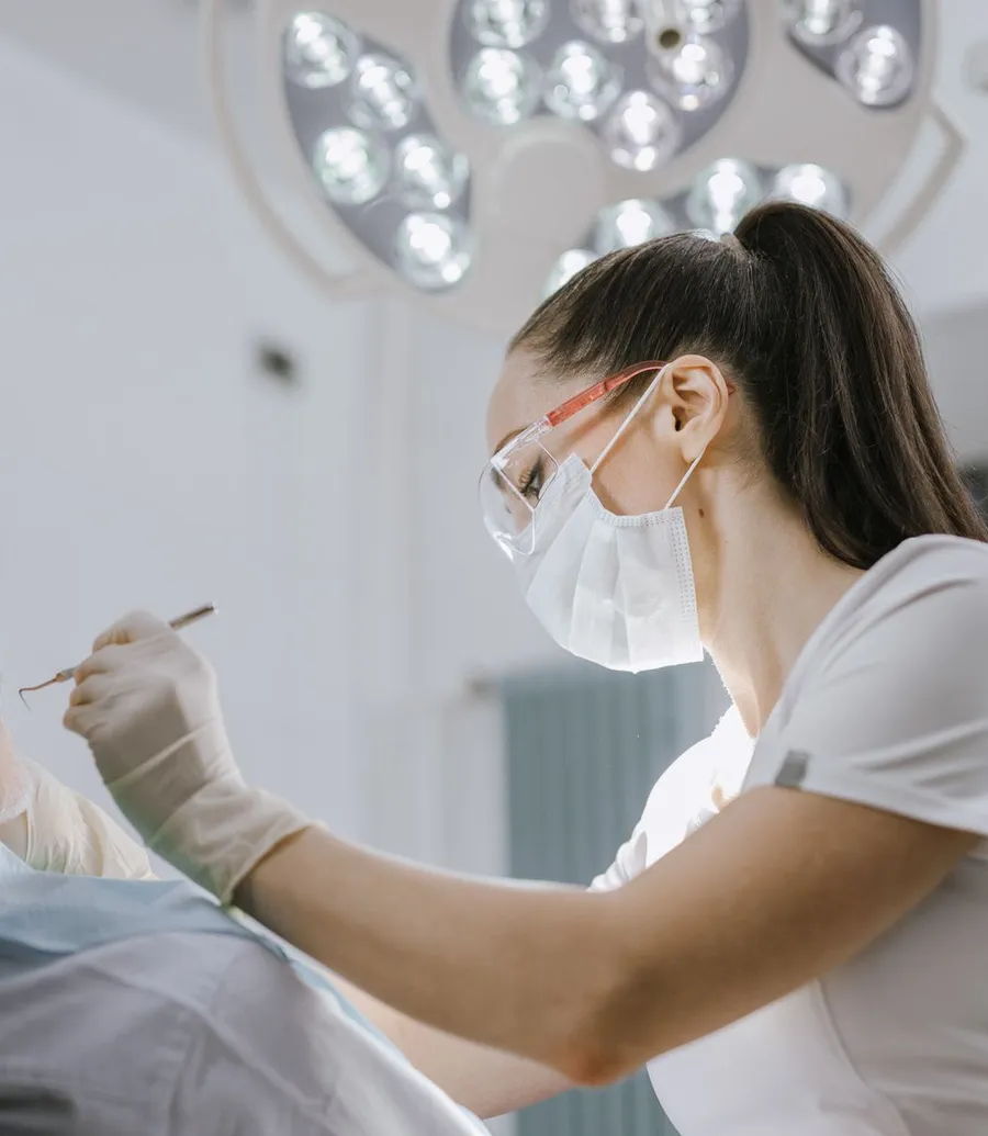 Dentist examining an older patient in the chair under an overhead light