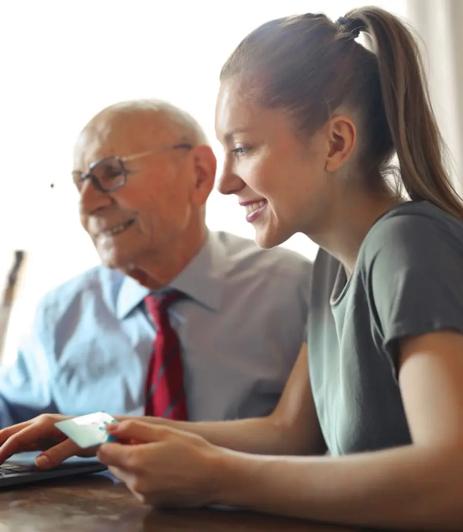 A financial advisor helping a client review something on a laptop