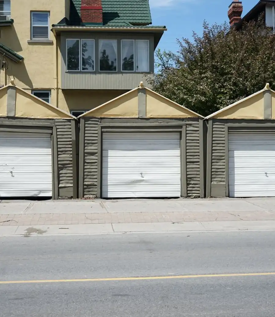 Row of white residential garage doors in daylight