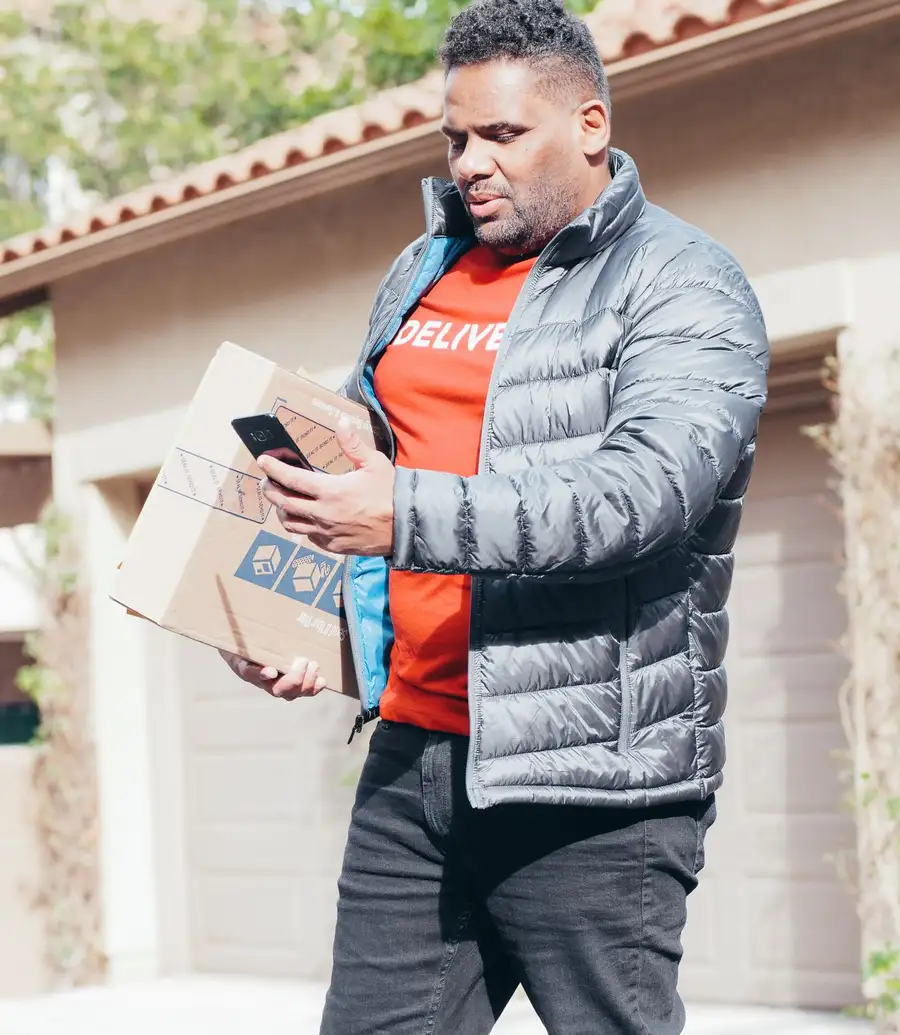 A worker checking a phone outside a home