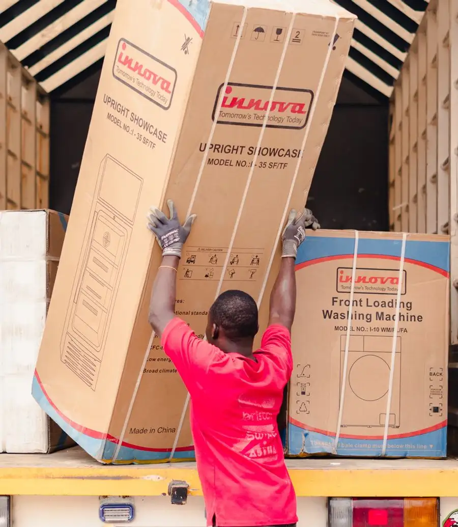 A worker loading boxed appliances onto a truck