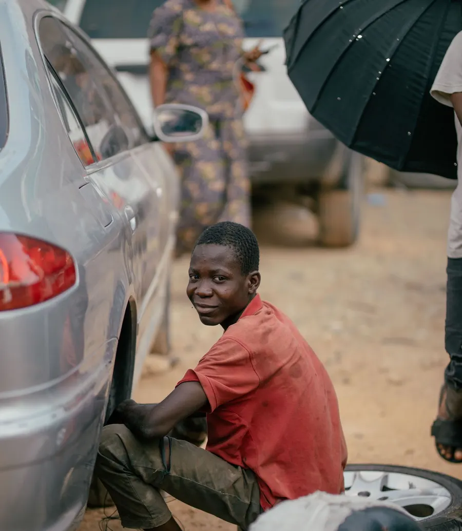 Mobile mechanic changing a tyre on a car at the roadside