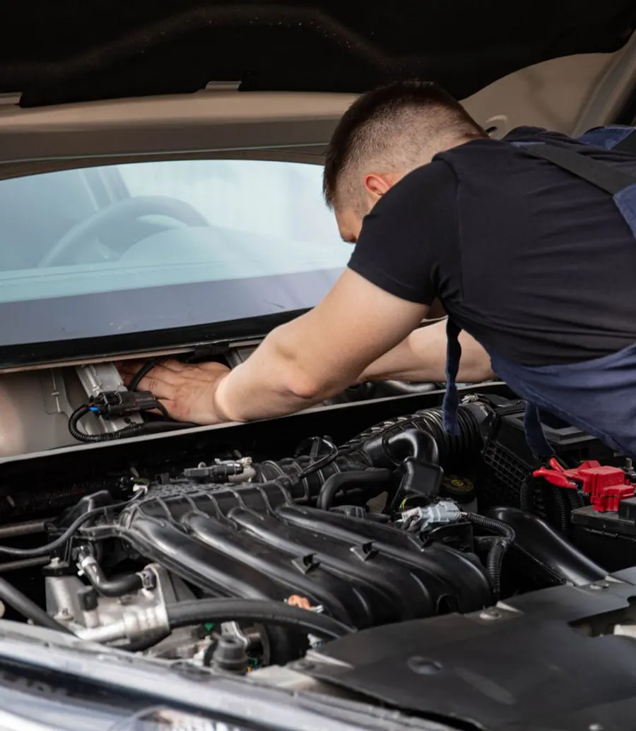 Close-up of a mechanic's hands working on a car engine