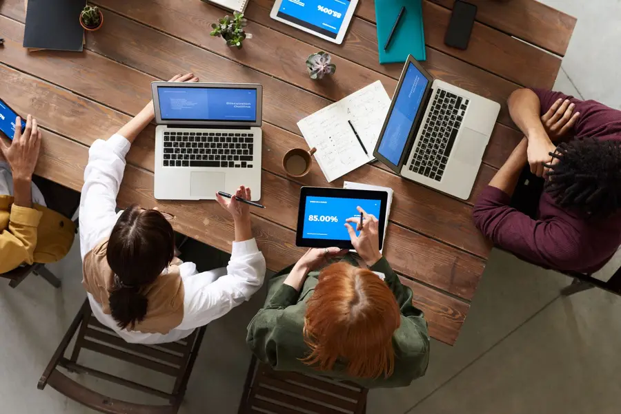 A work table covered in laptops and devices running the product