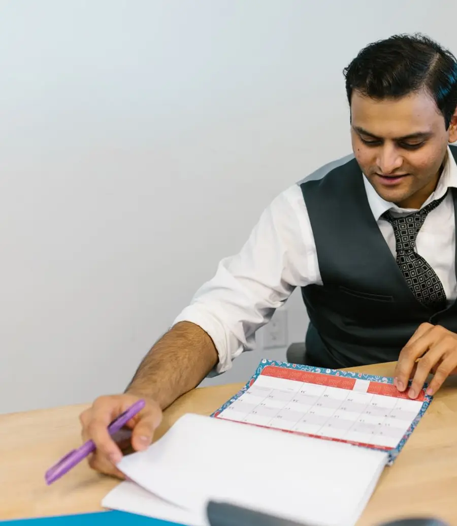 Therapist checking a calendar on a laptop in a bright office