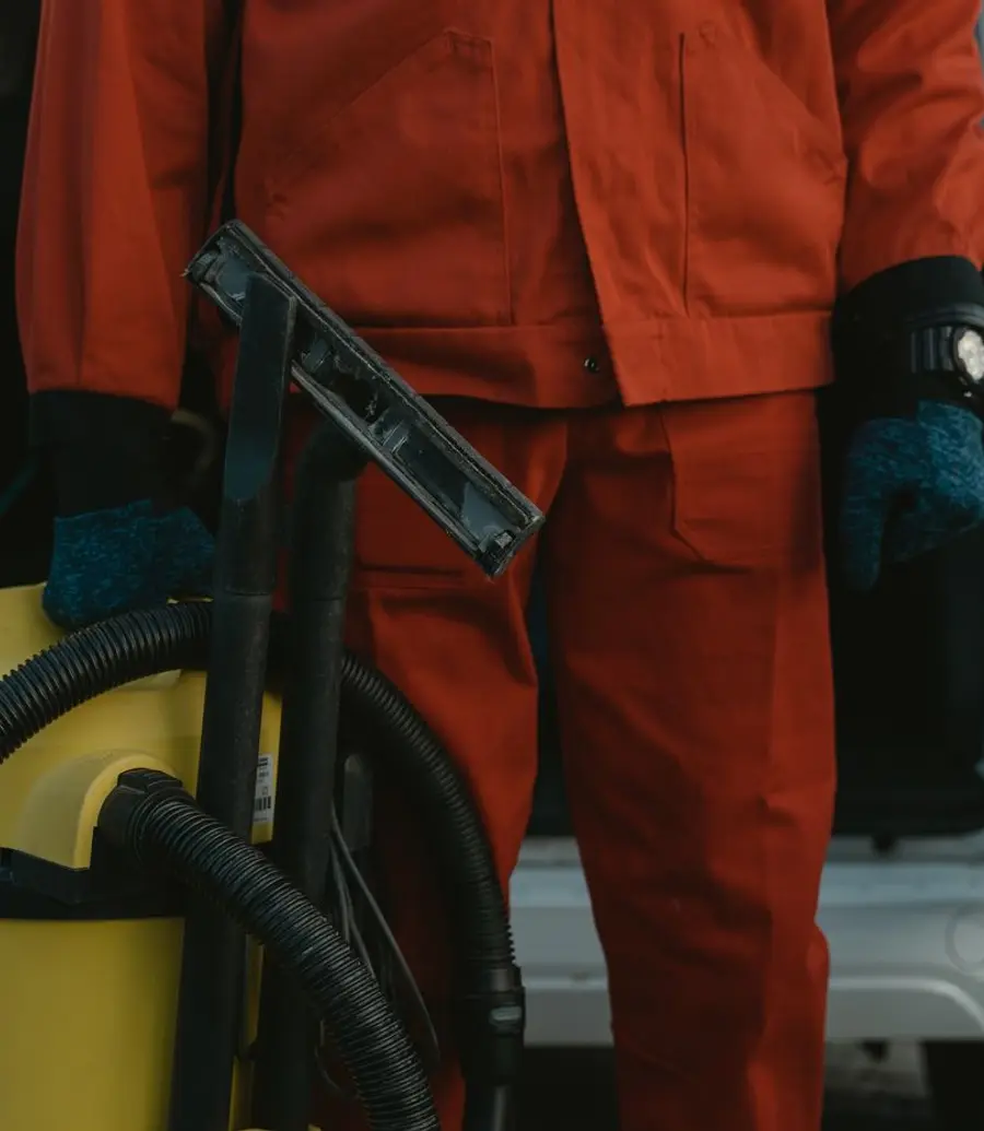 Restoration worker in uniform beside a service van with a water-extraction unit