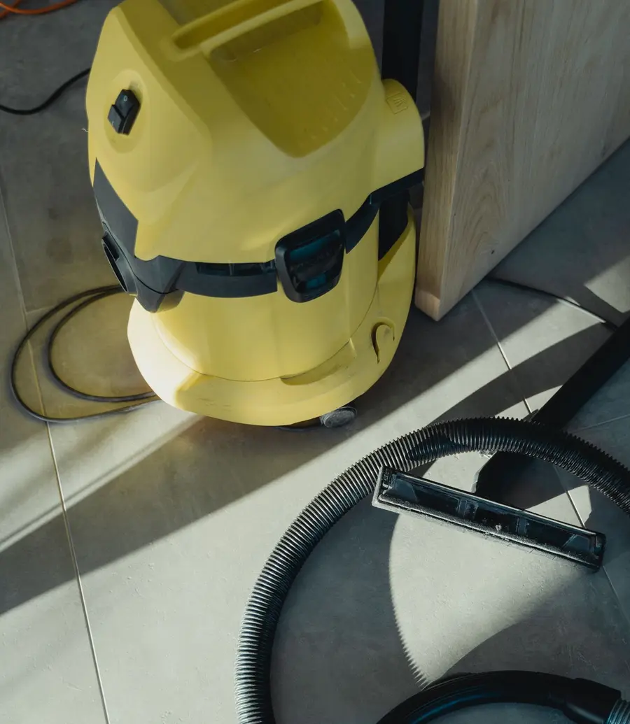 A wet and dry extraction vacuum on a tiled floor during a cleanup