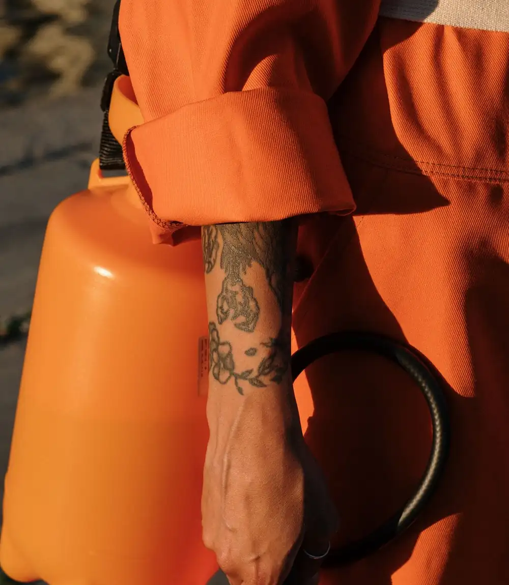 Wildlife-control technician carrying equipment in low evening light