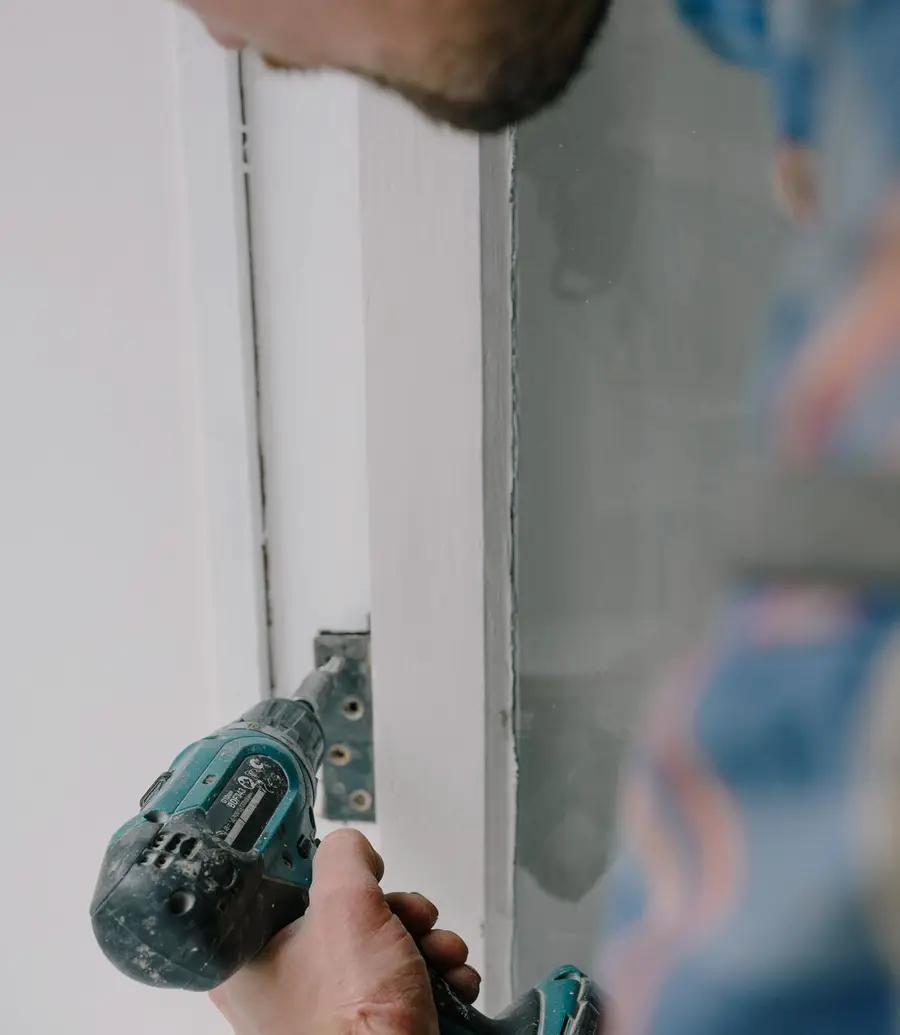 Person installing a new wooden window during a renovation